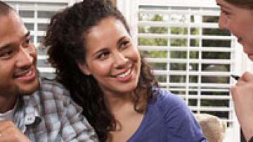 Man and woman listening to a woman while all smile